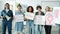 Group of women with feminist posters standing indoors and looking at camera with serious faces