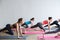 Group women on floor of sports gym doing push ups.