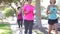 Group Of Women Jogging Down Urban Street