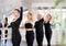 Group of women mastering third position at ballet barre