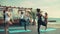 Group of women practicing yoga on the beach slow motion