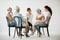Group of women sitting together during psychotherapy with senior counselor