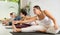 Group of women stretching head to knee Janu Sirsasana pose during yoga class. Focus on young female