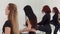 Group of women with their legs up on a barre during dance class