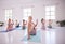 Group of women twisting, stretching in yoga class. Group of women in pilates class together. Flexible young women