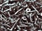 Group of wood  steel  screws , zinc heap chrome. Close up macro, dark industrial seamless background