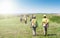 Group of workers in hardhats walking and inspecting grass field