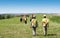 Group of workers in hardhats walking and inspecting grass field