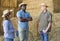 Group of workers resting on bales of hay after working on dairy farm