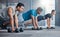 Group, workout and dumbbell push up at gym for muscle, power or strength. Teamwork, sports or energy of people, athletes