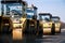 Group of yellow asphalt compactors on road