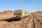 Group of yellow wagons with material for nitrogen fertilizers in desert