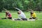 A group of yoga sportsmen performs breathing exercises in park