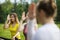 A group of yoga sportsmen performs breathing exercises in park