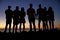 Group of young adults admiring sunset by the sea