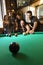 Group of young adults playing pool.