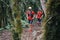 Group of young adults training and running together through trails on the hillside outdoors in nature