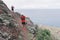 Group of young adults training and running together through trails on the hillside outdoors in nature