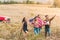 group of young american travellers with flag walking by flower field