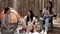 Group of young Asian friends camping or picnic together in forest, teenager female enjoy talking in front of tent. Women do