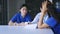 Group of young Asian male and female doctor and nurse sitting during break in canteen and discussing serious patient