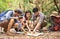 A group of young Asians are planning and looking at maps for camping in the forest.Asian and caucasian are backpackers.Tourism,