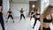 A group of young athletic girls with fitness instructor perform workout in the hall. Fitness training. Sports girls