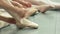 Group of young ballerinas taking off pointe shoes.