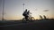 Group of young bikers friends hanging and riding on smoky bikes doing stunts and ollie tricks at the sunset in slow motion -