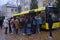 Group of young boys and girls standing in front of the school bus ready to get on