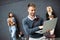 Group of young business people holding different digital devices outdoor