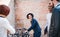 Group of young businesspeople with bicycle outdoors in courtyard, talking.