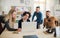 Group of young businesspeople with laptop having meeting in a modern office.