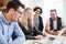 Group of young businesspeople with laptop working together in a modern office.