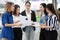 group of young businesswomen meeting in a conference wiht paper work and document outside office in urban city