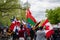 A group of young college students parading down a main street holding flags of various countries