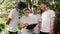 A group of young eco-activists, three guys and a girl, in orange gloves and white T-shirts, discuss and analyze a plan