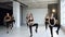 Group of young female people perform step aerobics in fitness centre. Pretty fitness girls together doing exercises on