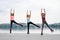 A group of young fit slim women in kangoo jumps, training in front of city lake in summer. Four sportswomen, wearing colorful