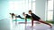 Group of young flexibility women doing yoga posture in bright yoga class.