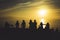 Group of young friends on background beach ocean sunrise, silhouette romantic people dances looking on rear view evening seascape