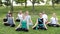 A group of young friends do yoga in nature. The concept of sports and recreation. Friends have a good time
