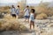 Group Of Young Friends Hiking Through Desert Countryside Together