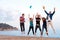 Group of young friends jumping on beach.