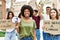 Group of young friends protesting and giving slogans at the street looking positive and happy standing and smiling with a