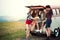 A group of young friends on a roadtrip through countryside, looking at map.