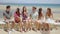 Group of young friends sitting on a seafront wall