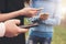 The group of young friends teenagers using mobile at the city street, close up focus on hands