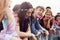 Group Of Young Friends Waiting Behind Barrier At Entrance To Music Festival Site