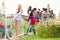 Group Of Young Friends Waiting Behind Barrier At Entrance To Music Festival Site